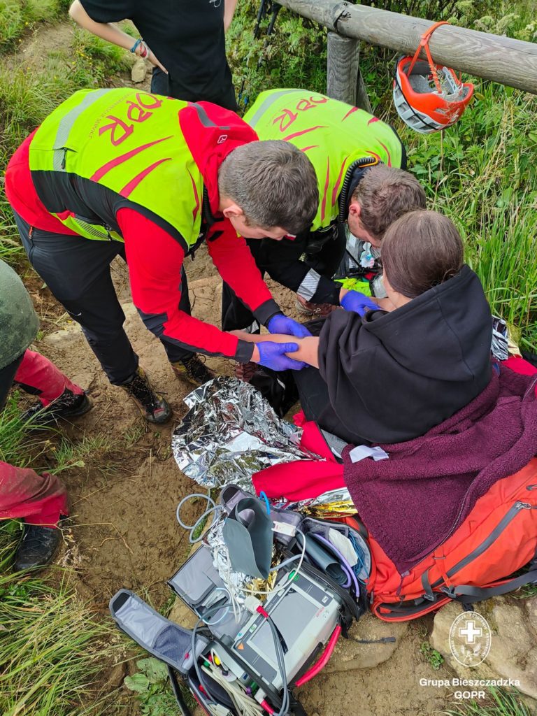 Dwóch ratowników udziela pomocy turystce