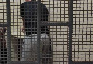 Cela, za kratami sylwetka mężczyzny