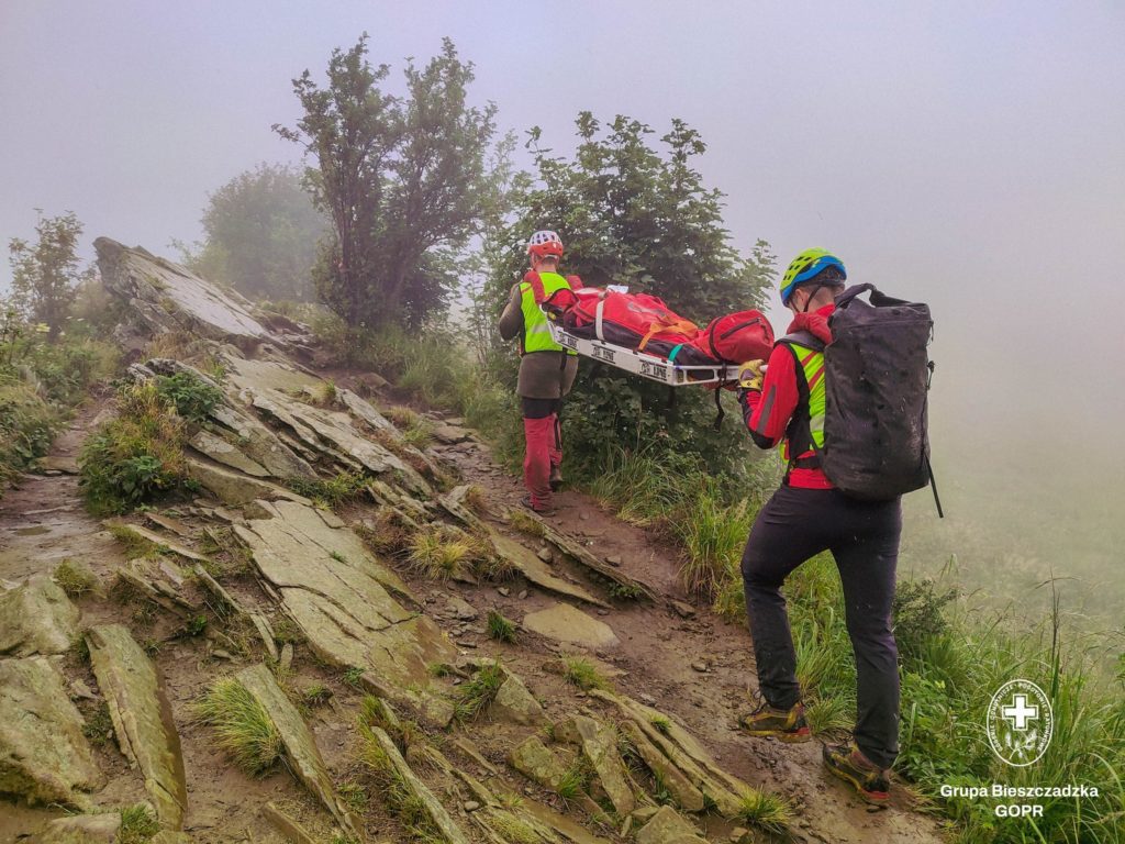 Dwóch ratowników niesie nosze na ramionach