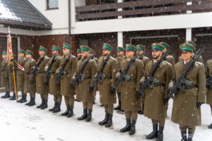 Zołonierze w szeregu stoją na ośnieżonym placu